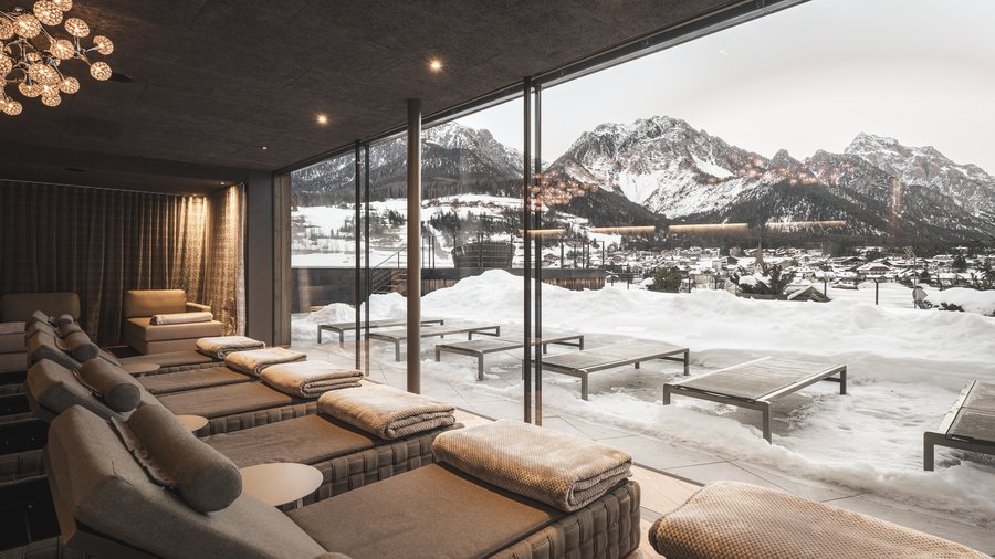 Hotel in the Dolomites for adults only Cozy loungers in spa area with mountain view and snow outside