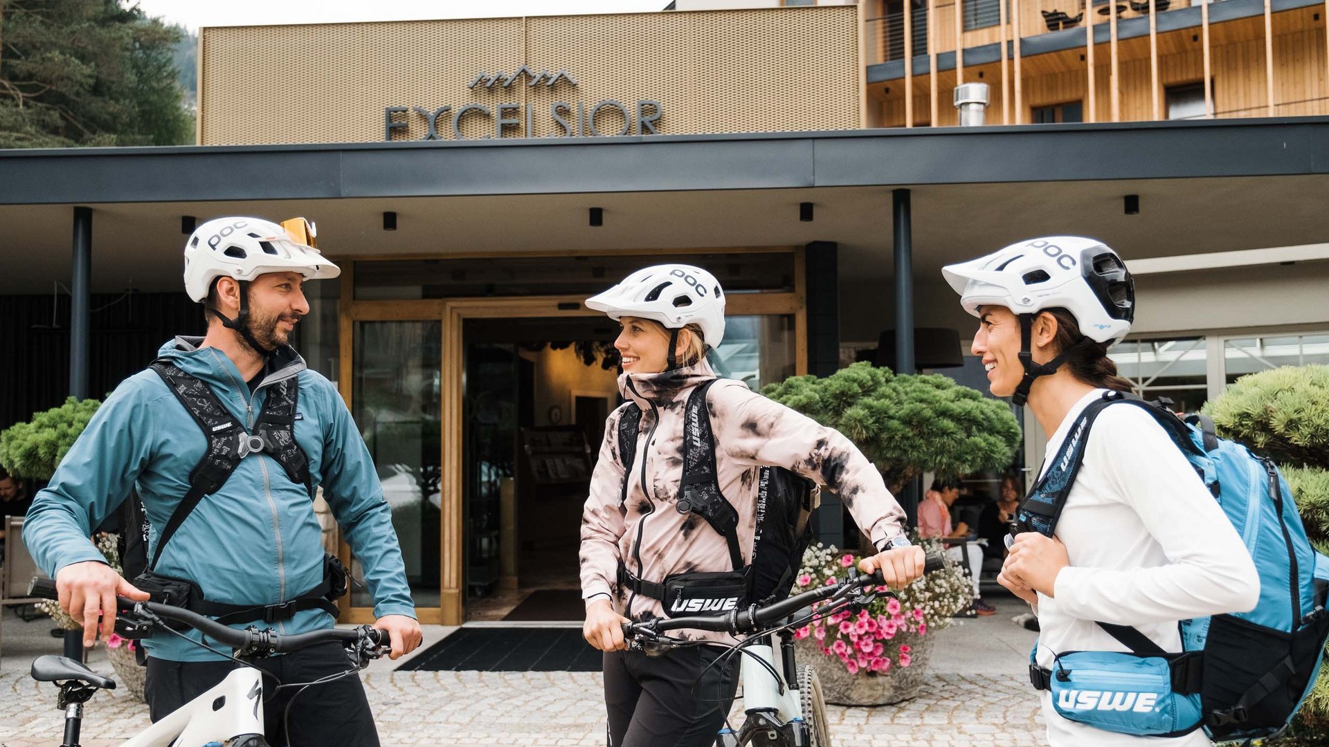 Regione bike Tre ciclisti con caschi davanti all'hotel Excelsior che conversano