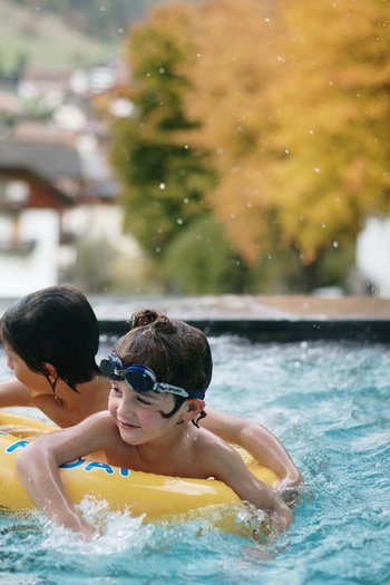 Excelsior: hotel wellness in Alto Adige per famiglie Due bambini che giocano in piscina su un ciambellone giallo