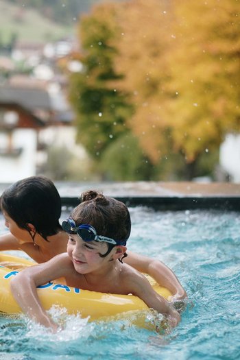 Excelsior: hotel wellness in Alto Adige per famiglie Due bambini che giocano in piscina su un ciambellone giallo