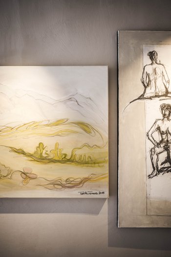 Art in the design hotel in South Tyrol Two modern paintings on a wall, one landscape and one nude sketches