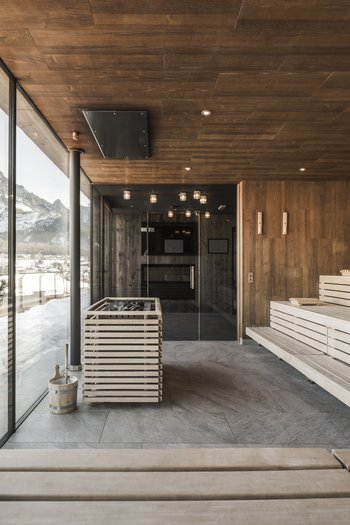 Hotel con infinity pool in Alto Adige: l’Excelsior Sauna moderna con vista sulle montagne innevate attraverso grandi finestre