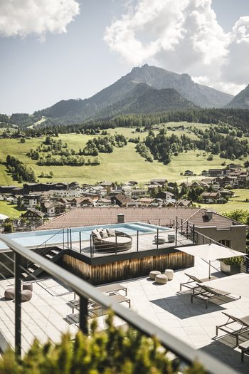 Hotel con infinity pool in Alto Adige: l’Excelsior Terrazza sul tetto con piscina e vista panoramica su montagne e villaggio