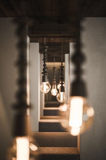 Hotel con infinity pool in Alto Adige: l’Excelsior Serie di lampade sospese moderne in un corridoio con luce calda