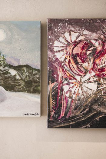 Art in the design hotel in South Tyrol Two abstract paintings on a wall, one with mountain landscape, one colorful and dynamic