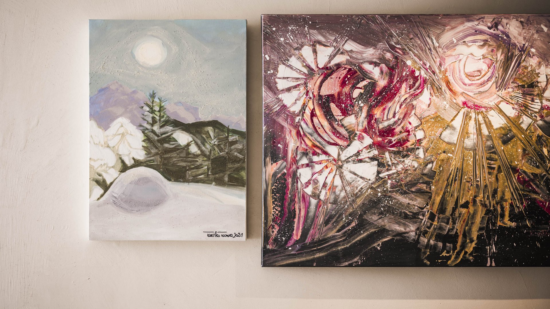 Art in the design hotel in South Tyrol Two abstract paintings on a wall, one with mountain landscape, one colorful and dynamic