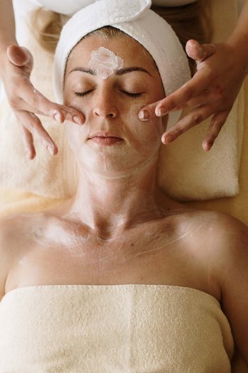 Wellnesshotel in den Dolomiten Frau erhält Gesichtsmassage mit Creme im Spa
