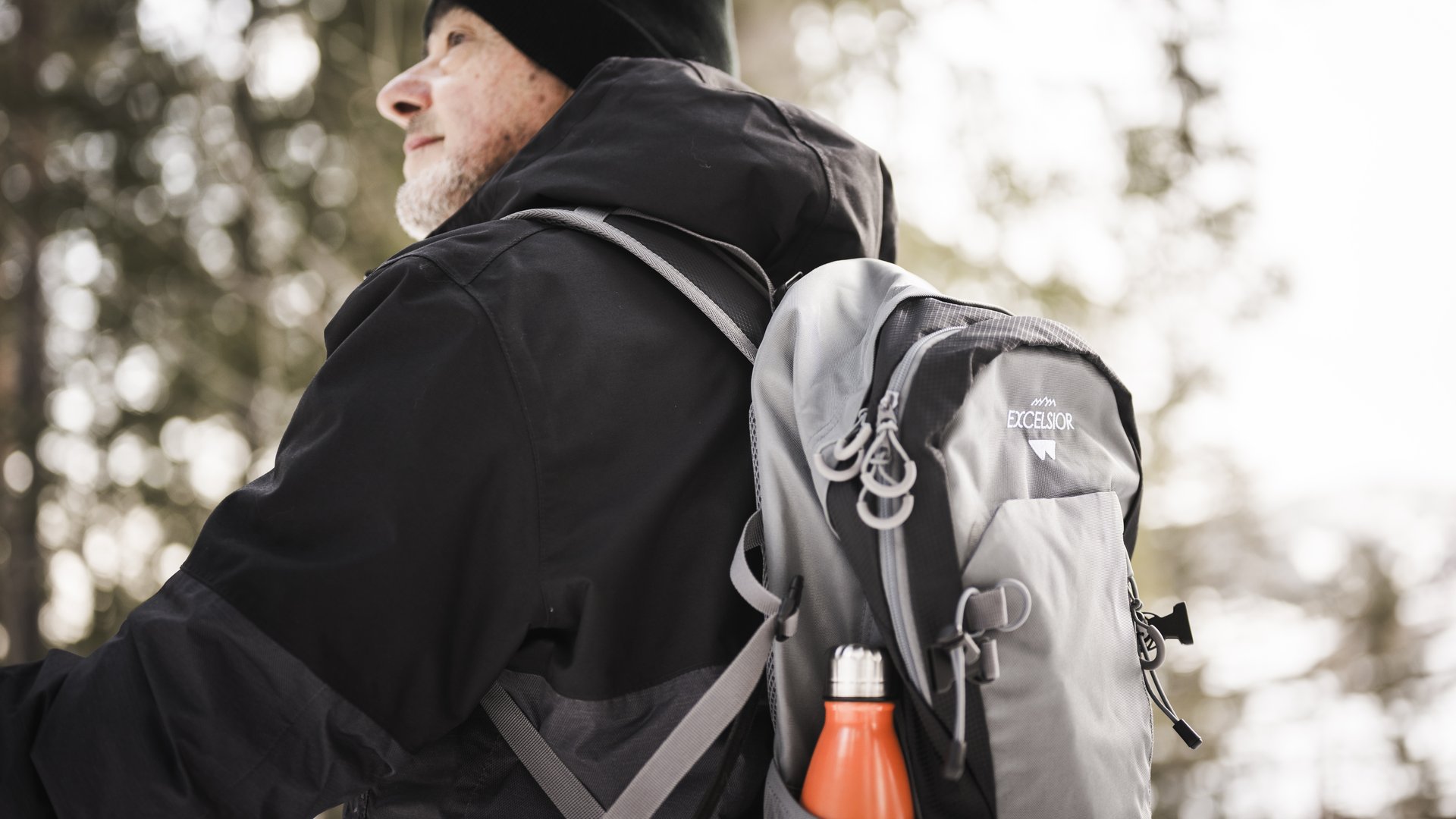 Escursioni a San Vigilio di Marebbe e non solo Uomo anziano con giacca nera e zaino grigio nella foresta