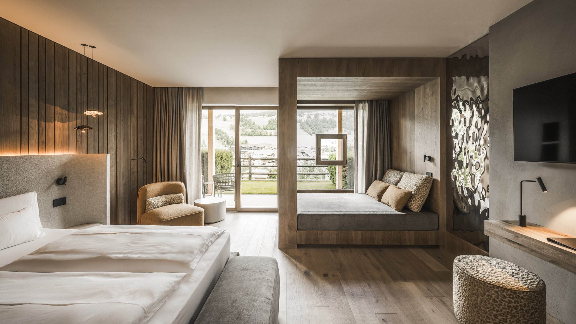Modernes Hotelzimmer mit Holzdetails, großen Fenstern und gemütlicher Sitzecke