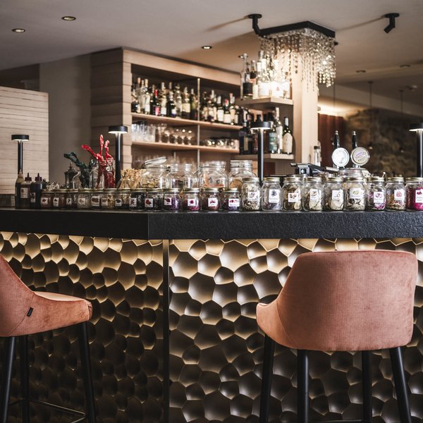 A San Vigilio di Marebbe: un hotel da sogno Bar con sgabelli rosa e numerosi barattoli di spezie e erbe sul bancone